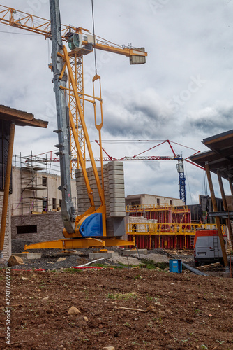 Chantier avec grues sous un ciel nuageux