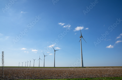 A row of wind turbines in the vast landscape of the province of Groningen, near Eemshaven in the north of the province.