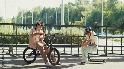 Two 10 Year Old Boys Distracted by Smartphones with BMX and Scooter