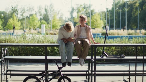 Two Boys Sitting and Laughing Together in Park