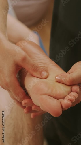 close-up of hands massaging relaxed foot sole with thumb pressure on arch and kneading ball for relief warmth