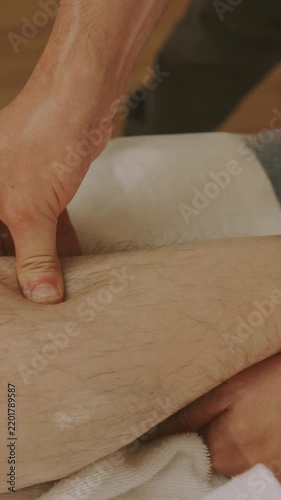close-up scene shows hands kneading calf over towel, skin compressing and gliding with pressure under light.