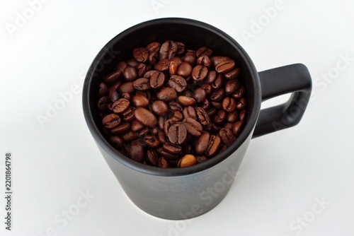 Принти на полотні Mainz, Rhineland Palatinate, Germany: Roasted coffee beans filling black ceramic mug on clean white background
