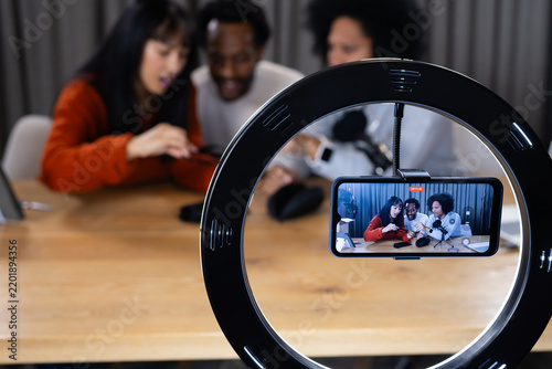 Diverse content creators recording live stream at home with ring light smartphone microphone