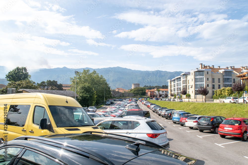 Obraz premium Llanes parking lot filled with cars by mountains