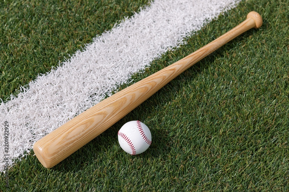 Obraz premium The Baseball Bat Resting On Green Field Beside White Line
