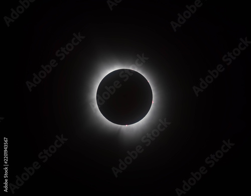 A total solar eclipse glows against the dark night sky.