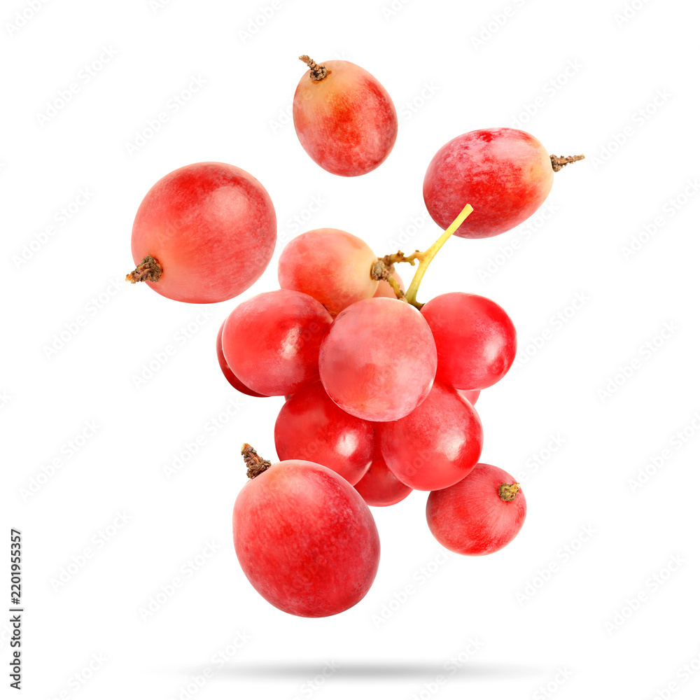 Obraz premium Fresh pink grapes falling against white background