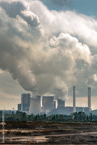 Large brown-coal power plant with tall chimneys and huge smokestacks rising against the sky. Part of coal-fired electricity generation, fossil fuel use and energy production.
