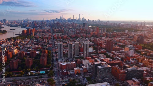 Red brick buildings prevailing in the city panorama. Footage over East Harlem at sunset. Midtown Manhattan skyline in the backdrop.