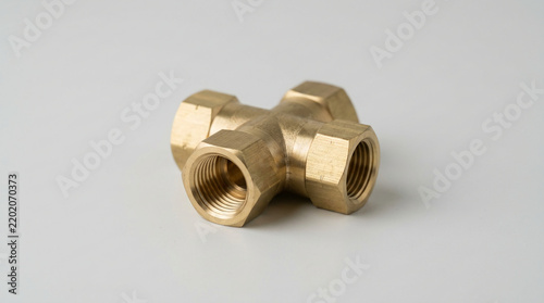 Clean solid brass pneumatic cross fitting on neutral background
