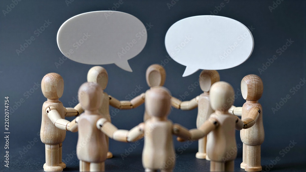 Obraz premium Wooden figures in circle, speech bubbles above heads, symbolizing group discussion or collaboration.