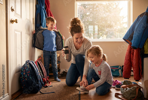 Mother helps daughter with shoes before leaving home