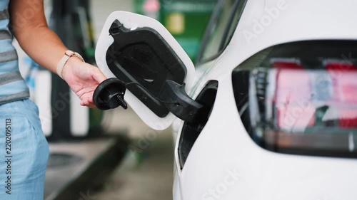 Woman refueling car amid rising gas prices and oil crisis