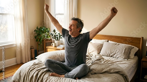 Mature man waking up in bed stretching arms and smiling happily