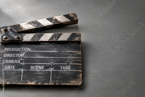 Weathered wooden film clapperboard on grey surface for filmmaking and cinema production concept