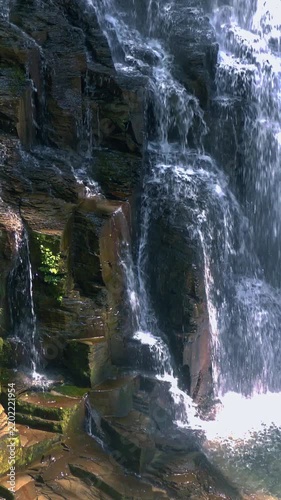 Falling Water Over Dark Rock Face Close Up Vertical Video