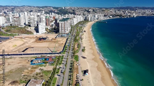 Drone view of Viña del Mar showing its sandy beach, coastal avenue, high-rise skyline, Vergara Pier and blue Pacific Ocean.
