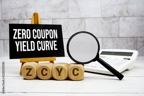 ZCYC Zero Coupon Yield Curve text with calculator magnifying glass and on wooden background