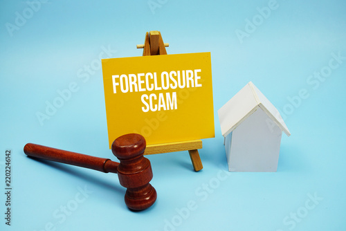 Fotografie Foreclosure Scam text with judgment gavel and house model on blue background