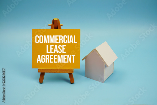 Commercial Lease Agreement text with house model on blue background