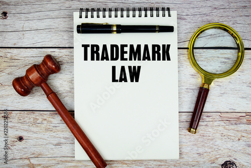 Obraz na płótnie Trademark Law text written on notepad with wooden judgment gavel and magnifying