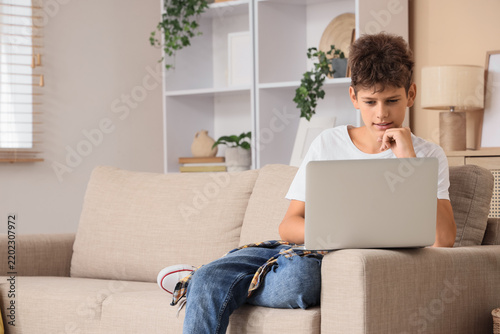 Remote learning and digital education, teenage boy using laptop for online sc...