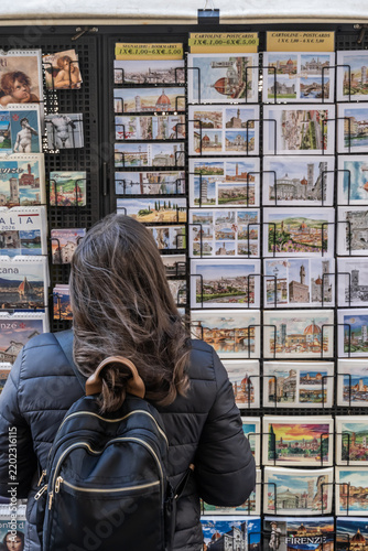 Florence Italy Tourist Postcards Souvenirs Shopping Travel Market Culture Street. Tourist browsing postcards and souvenirs at a street display in Florence, Italy