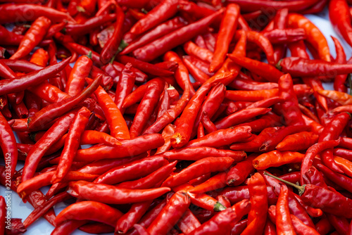 Fotografie Fresh Red Chili Peppers Piled at Asian Food Market as Spicy Ingredient Backgroun