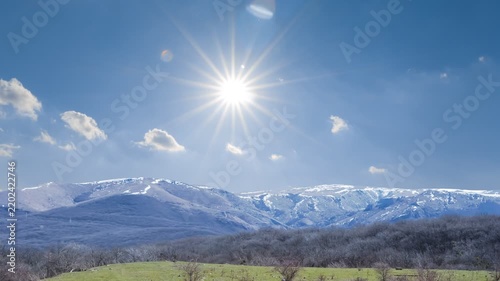 snowbound mountain ridge under a sparkle sun time lapse scene