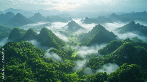 Aerial View Of Lush Green Limestone Peaks With Rolling Morning Mist And Soft Sunlight At Sunrise