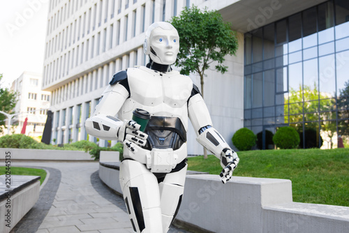 Futuristic robot walking with coffee container