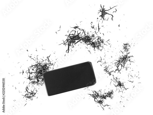 Black eraser crumbs and black eraser on a white background, top view. Education concept.