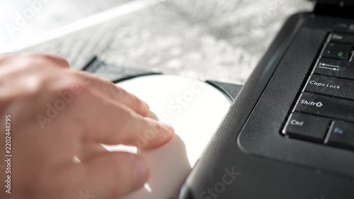 Person Inserting CD DVD Disc into Laptop Optical Drive