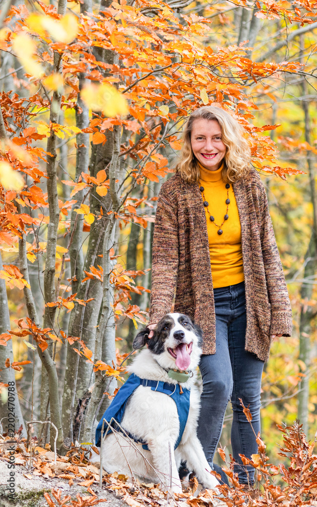 Fototapeta premium happy woman with dogs playing outdoors in autumn forest