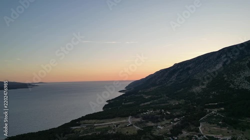 Stunning sunset behind the mountains on a peaceful Croatian island, with warm golden light, dramatic silhouettes and a beautiful tranquil Mediterranean landscape.