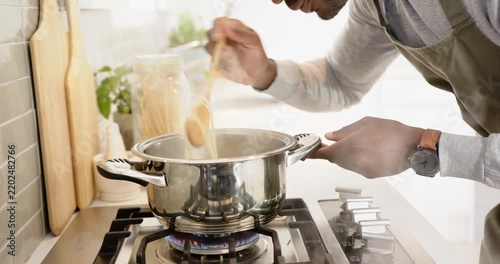 Lifestyle videos indoor of people doing activities at home, cooking pasta sauce in frying pan on sto
