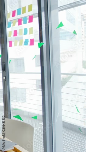 Vertical video: On playback green triangles rising and fading across glass door notes for design