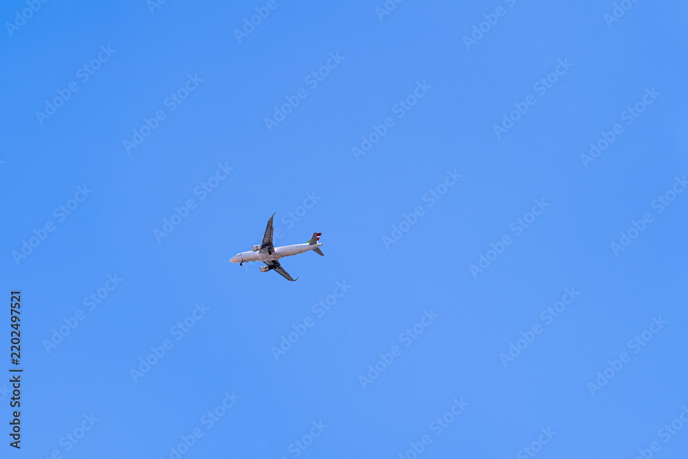 Obraz premium Airbus Aircraft against a solid blue sky, silhouette plane, Lisbon, Portugal.