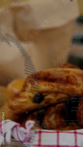 Vertical video: Slow pan showing glazed pastry stack, bag and fruit on red towel, selling pastries