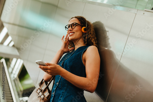 Commuting woman chats through headphones in an underground metro station