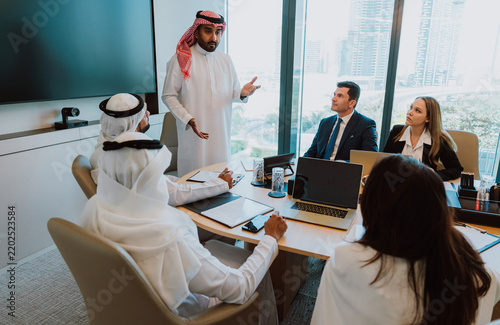 Arab saudi businessman leading meeting and discussing strategy with team