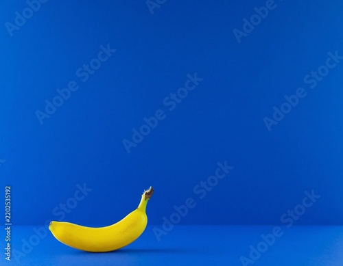 Yellow banana on blue background with copy space