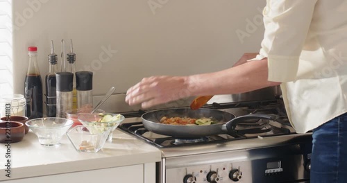 Lifestyle videos indoor of people doing activities at home, cooking vegetables in frying pan, person