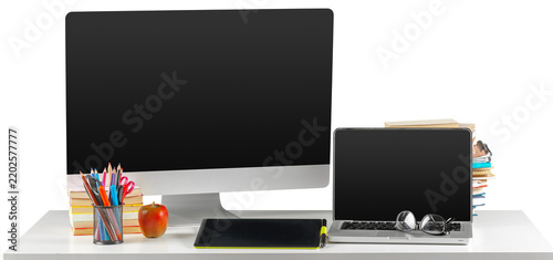 Workspace with a desktop computer, laptop, and supplies on a white table