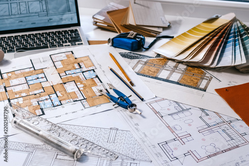 architect Eco retrofit planning with blueprints, material swatches and finish samples, sustainable renovation budget and healthy material selection concept for honest architectural design.