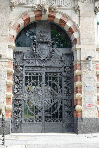 The ornate wrought-iron portal and arched entrance of the historic former commercial building 