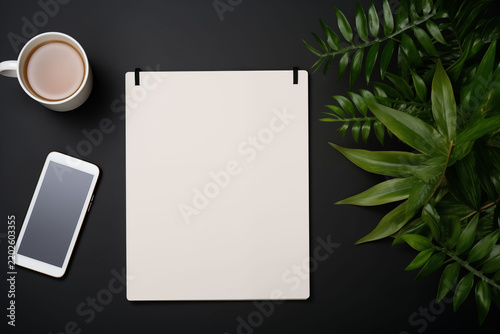 Minimalist creative workspace with a flat-lay arrangement featuring a laptop and a blank sketch.