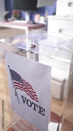 Putting ballot paper into transparent box at polling station for US elections