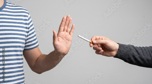a person refusing a cigarette. clear “stop” or “no” gesture. a hand offering cigarette and another hand refuse it. Healthy lifestyle concept. No Tobacco concept. No smoking concept.